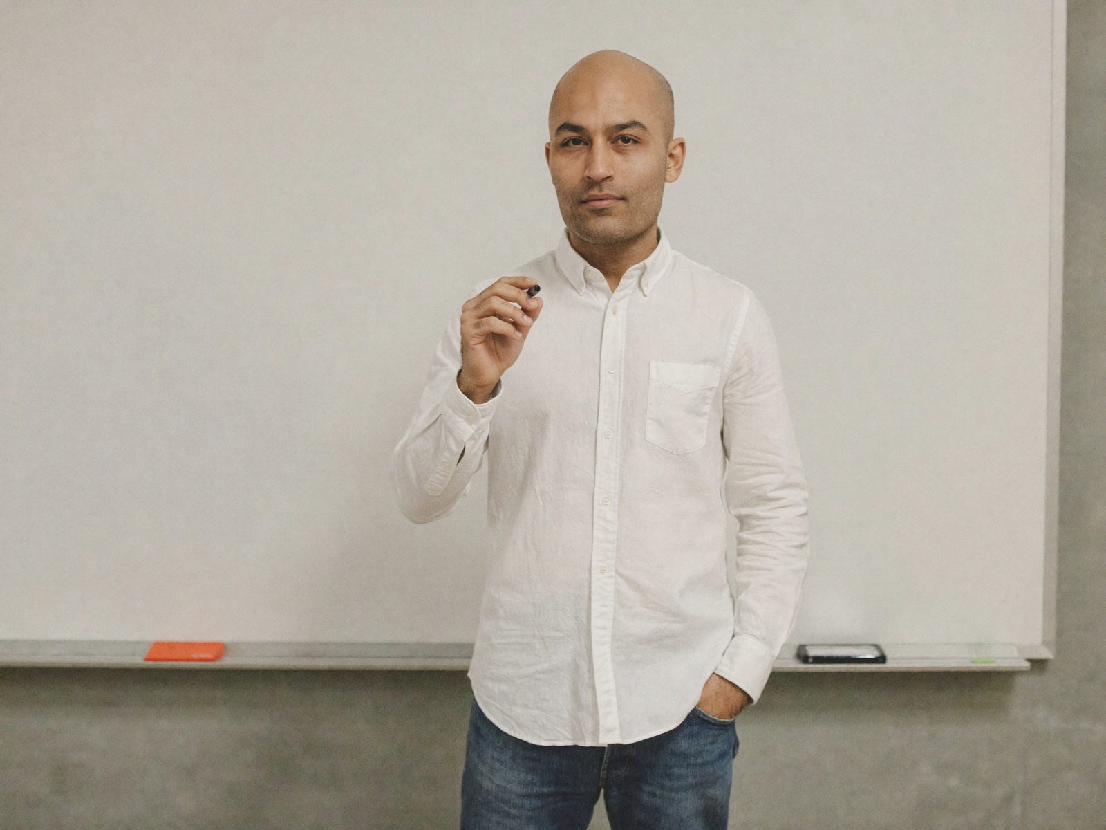 A person holding a marker in front of a whiteboard